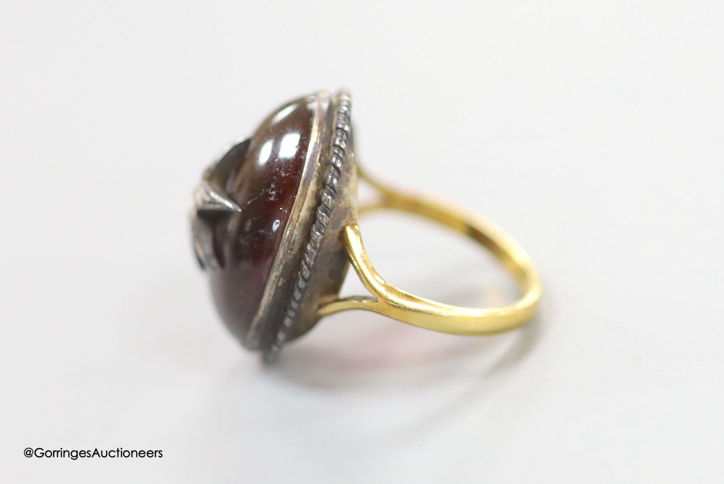 A 19th century yellow and white metal, oval cabochon garnet and rose cut diamond set ring, with central star motif, size L/M, gross 7.9 grams.